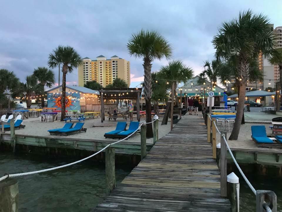 view of paradise bar and grill from sound with umbrellas and people on waterfront